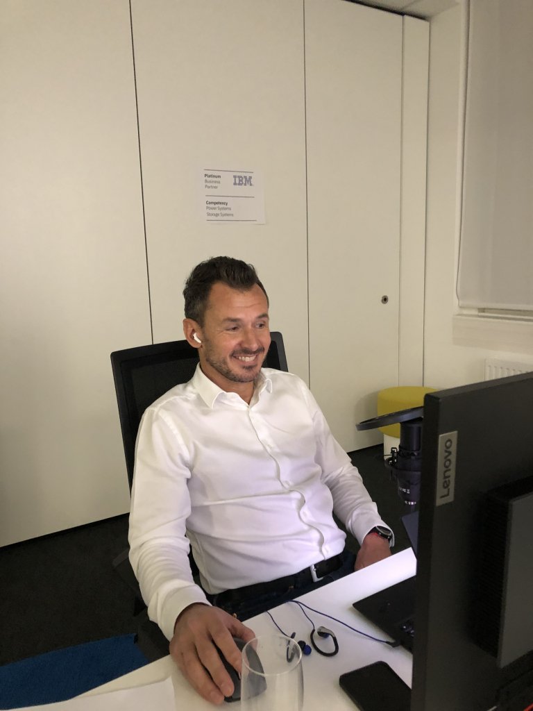Am Bild sieht man Werner Höger, der an seinem Event-Arbeitsplatz sieht und happy grinst.