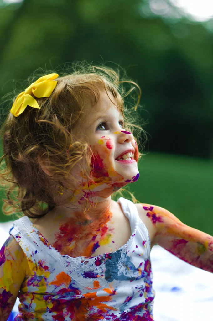Kleines Mädchen voll mit Farbklecksen