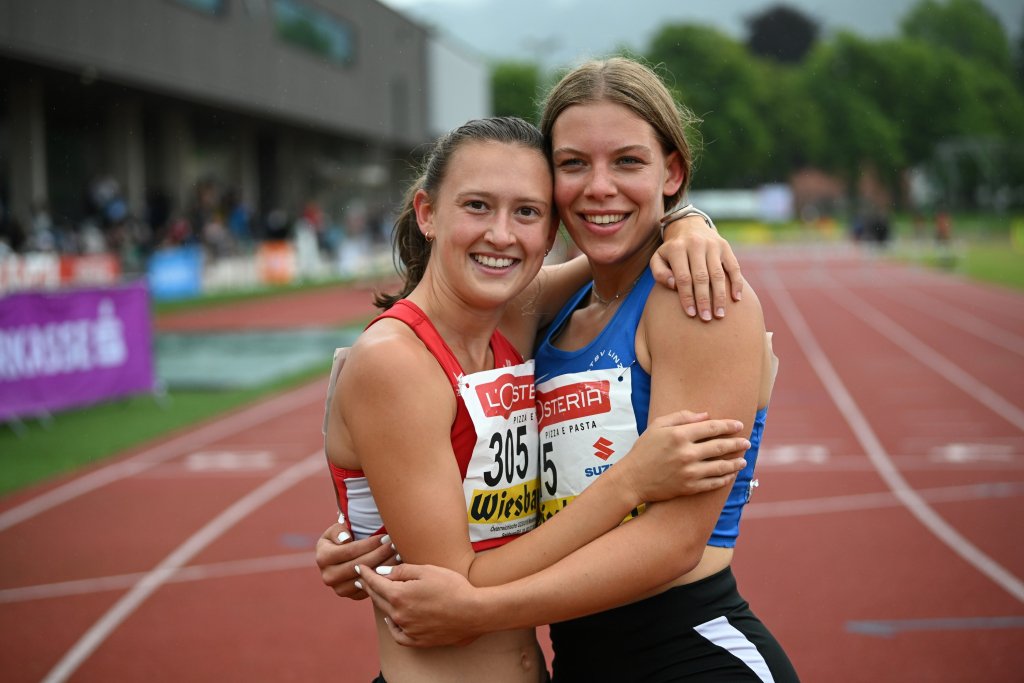 Das Bild zeigt Anja Dlauhy und ihre Kollegin Sophie Kreiner, die sich umarmen und in die Kamera lächeln.