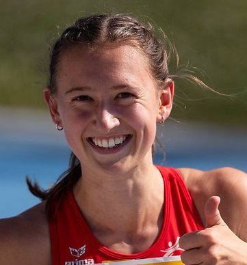 Das Bild zeigt Anja Dlauhy in ihrem Leichtathletikdress mit glücklichem Gesichtsausdruck und Daumen-Hoch Handhaltung.