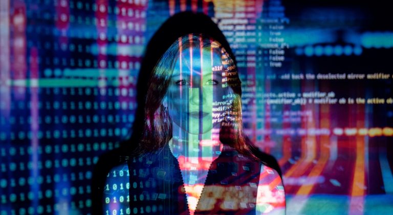 Das Bild zeigt eine Frau auf die ein Code-Bild projiziert wird.